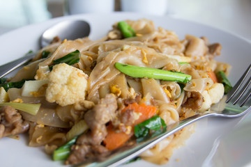 Stir fry noodles  in white bowl.