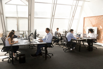 Fototapeta na wymiar Diverse workers sitting at desk working in coworking space