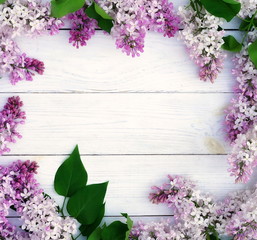 Floral pattern of a branch of lilac and other spring flowers on a white wooden background. top view. flat lay. Holiday concept. Copy space