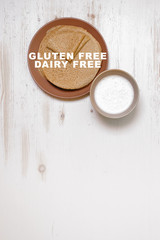 Gluten free pancakes wiht almond milk on white wooden background.