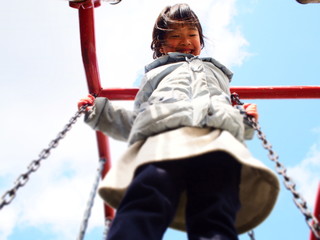 ブランコで遊ぶ笑顔の女の子