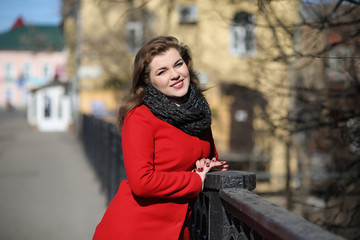 Obraz na płótnie Canvas Pretty girl on a walk in red coat in the city