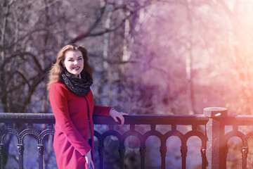 Pretty girl on a walk in red coat in the city