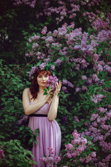 beautiful girl in purple dress with lilac flowers