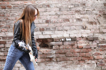  A rock musician girl in a leather jacket with a guitar