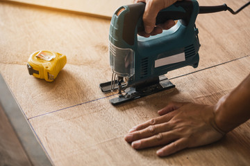 Carpenter working on woodworking machines in carpentry shop.The carpenter in workshop marks out the...