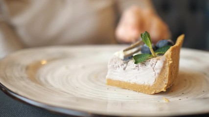 close up of female hands eating cheese cake in the cafe, selective focus