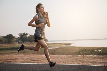 Young woman running in the nature. Healthy lifestyle and sport concepts.  Runner training in a...