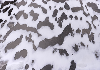 The surface of the frozen water and fallen snow in the wind.