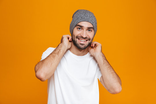 Image of happy man 30s with beard and mustache smiling while standing, isolated over yellow background