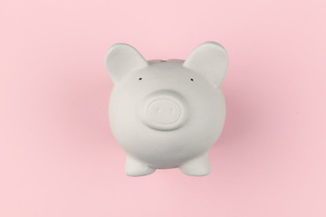 White piggy moneybox on pink background. Financial concept