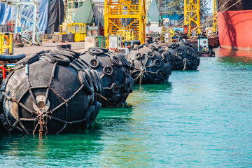 yokohama type of fender boating in floating installs in jetty of port against at marine vessel...