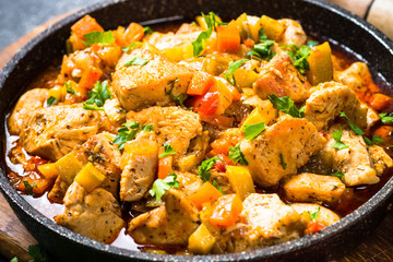 Chicken stew with vegetables black stone table, top view.