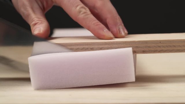 A front view of knife cutting off a piece of furniture poly foam