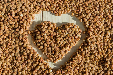 buckwheat background with drawn heart. Gluten free and healthy diet. Shallow depth of field.