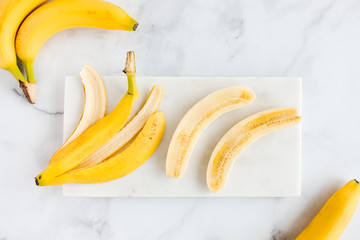 Banana Peel and Bananas on White Marble Board