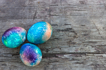 Colorful group of dyed or painted Easter eggs scattered on a rustic wooden table