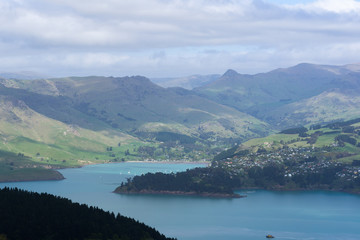 Bay surrounded by green hills with dramatic sky and extraordinary shadow play