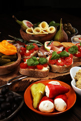 Italian antipasti wine snacks set. Cheese variety, Mediterranean olives, pickles, Prosciutto di Parma, tomatoes, artichokes