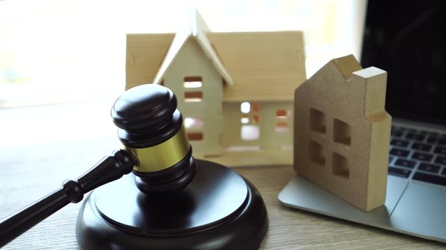 Judge gavel and house model on Notebook computer, Online Auction for Real Estate concept. Ideas for housing business judgment by E-commerce online goods services digital technology held over internet.