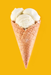 ice cream balls with colored sugar sprinkles in a Waffle Cone on a yellow Background. Vanilla ice cream in a waffle cone.