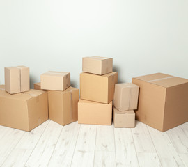 Day moving. Delivery of goods, shopping. Cardboard boxes on gray wall background. Copy space for text.