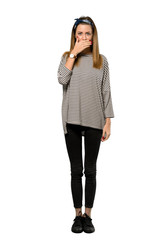 A full-length shot of a Young woman with headscarf covering mouth with hands for saying something inappropriate over isolated white background