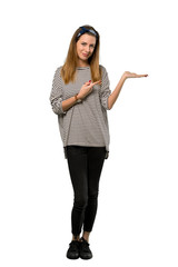 A full-length shot of a Young woman with headscarf holding copyspace imaginary on the palm to insert an ad over isolated white background