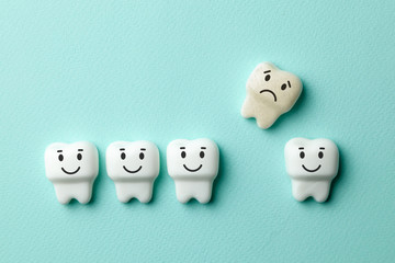 Healthy white teeth are smiling and removing yellow tooth with caries is sad against green mint...