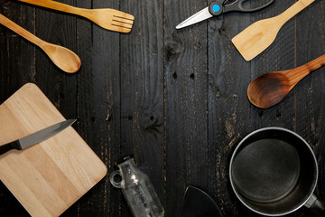 Set of kitchenware on the black wooden background