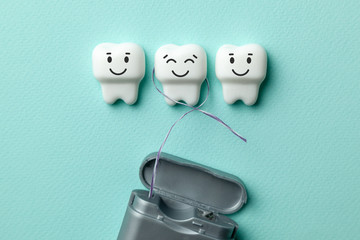 Healthy white teeth are smiling on green mint background and floss.