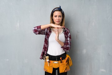 Craftsmen or electrician woman making time out gesture