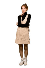 Fototapeta premium A full-length shot of a Young redhead woman thinking an idea while looking up over isolated white background