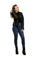 A full-length shot of a Teenager girl with leather jacket thinking an idea while scratching head on isolated white background