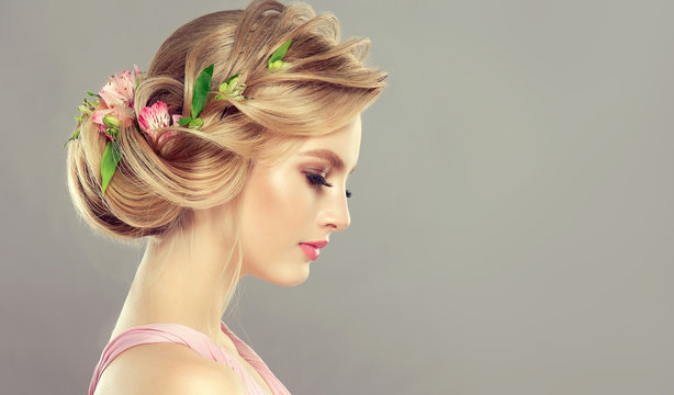 Beautiful Model Girl  With Elegant Hairstyle And Rose Flowers In A Plait . Woman With Fashion  Spring Hair.