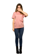 A full-length shot of a Teenager girl with pink sweater takes hands on head because has migraine on isolated white background
