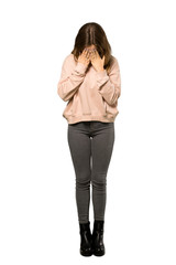 A full-length shot of a Teenager girl with pink sweater with tired and sick expression over isolated white background