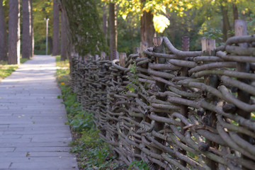 Wooden fence in the garden at pathway background.
