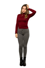 A full-length shot of a Teenager girl with turtleneck with an expression of frustration and not understanding over isolated white background