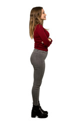 Fototapeta premium A full-length shot of a Teenager girl with turtleneck in lateral position over isolated white background