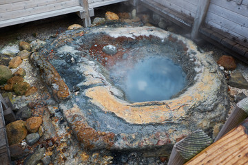Clear blue sky and sulfur gas steaming out from ground at Noboribetsu Jigokudani or Hell Valley in Hokkaido, Japan	