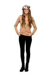 Fototapeta premium Full-length shot of Young woman with beret posing and laughing looking to the front on isolated white background