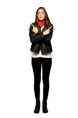 Full-length shot of Young woman with leather jacket pointing to the laterals having doubts on isolated white background