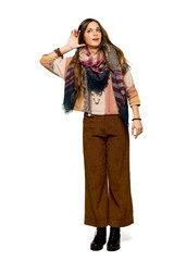 Full-length shot of Young hippie woman listening to something by putting hand on the ear on isolated white background