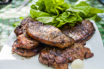 grilled beef steak with vegetables on white plate