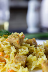 Macro traditional pilaf, rice with meat, carrots and onions on a white background.