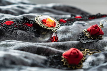Women's decoration black and red on a velvet gray background. Red roses of fabric, openwork...
