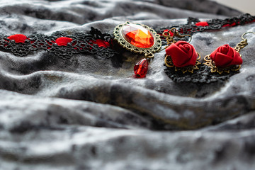 Women's decoration black and red on a velvet gray background. Red roses of fabric, openwork...