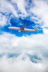 Fototapeta na wymiar An airplane flying in the blue sky. passenger plane flies highly over clouds of aerosphere. airplane flying in a clear pale blue sky. An airplane taking off at airport.