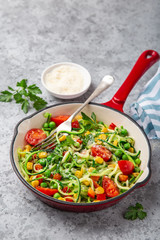 zucchini noodle with tomato, corn and green peas on pan, healthy vegan food